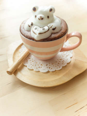 Bear hugging heart in coffee cup. Adorable latte art 3d design.の写真素材