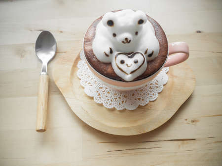 Bear hugging heart in coffee cup. Adorable latte art 3d design.の写真素材
