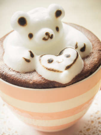 Bear hugging heart in coffee cup. Adorable latte art 3d design.の写真素材