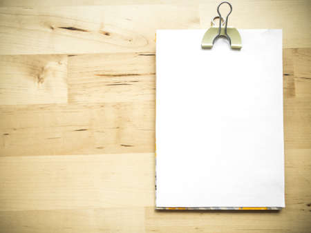 White blank note paper and cliped on wood background with copy space