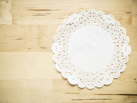 Lace paper on wooden table backgroundの写真素材
