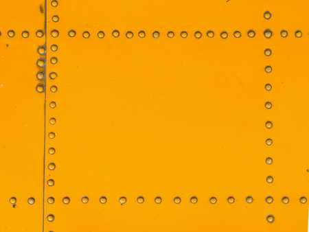 Yellow metal plate with pin background.