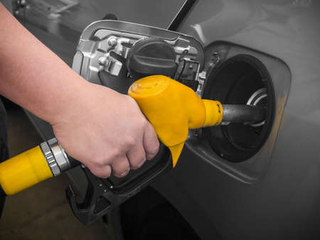 Pumping gas at gas pump. Closeup of man pumping gasoline fuel in car at gas station.の写真素材