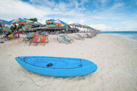 Canoe boat on the beach with seat and umbrella in the summer timeの写真素材