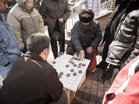 Dalian, China - January 22, 2015 : Chinese people play Xiangqi (Chinese Chess) at street side. It's popular board game in China and Asia.のeditorial素材