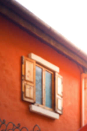 Blur background image of wooden window on saturate orange wall house.の写真素材