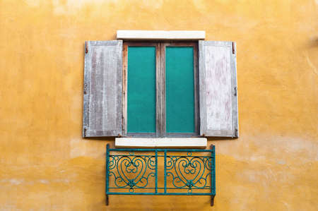 Background image of wooden window on saturate yellow wall house.の写真素材