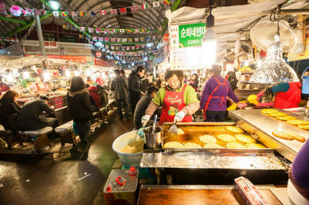 SEOUL, SOUTH KOREA - FEBRUARY 28, 2015 : People enjoying street food at Gwangjang Market.The market was established in 1905 .It has many restaurants and food stalls selling traditional Korean cuisine.のeditorial素材