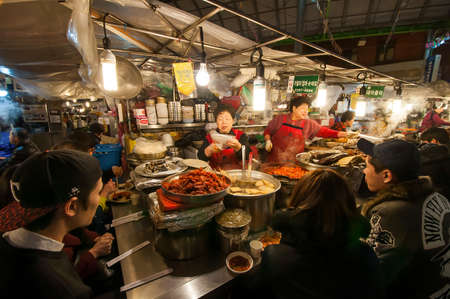 SEOUL, SOUTH KOREA - FEBRUARY 28, 2015 : People enjoying street food at Gwangjang Market.The market was established in 1905 .It has many restaurants and food stalls selling traditional Korean cuisine.のeditorial素材