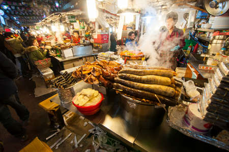 SEOUL, SOUTH KOREA - FEBRUARY 28, 2015 : People enjoying street food at Gwangjang Market.The market was established in 1905 .It has many restaurants and food stalls selling traditional Korean cuisine.のeditorial素材