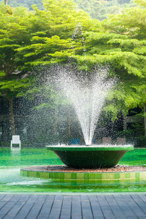 Fountain in fresh summer green pool.の写真素材