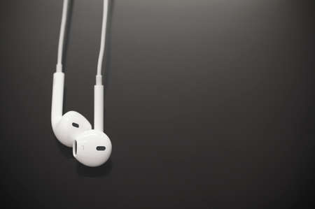 White earbuds on black screen backgroundの写真素材