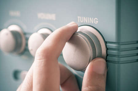 Hand tuning fm radio button. Retro image processed.