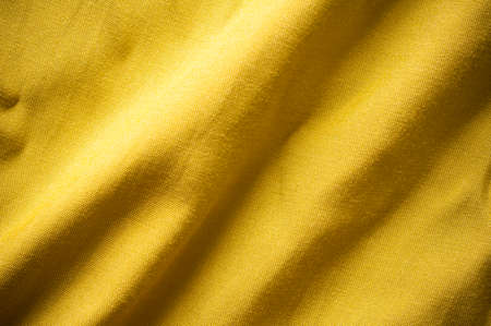Gold colour clothes fabric texture background.の写真素材