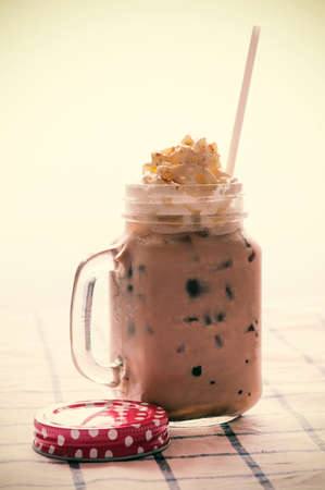 Ice latte with whipped cream in retro mug. Processed vintage filtered.の写真素材