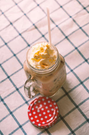 Ice latte with whipped cream in retro mug. Processed vintage filtered.の写真素材