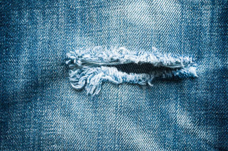 Blue denim jeans with tear closed up texture.の写真素材