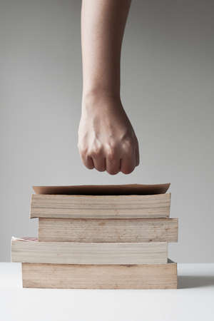 Fist over pile of old book.の写真素材