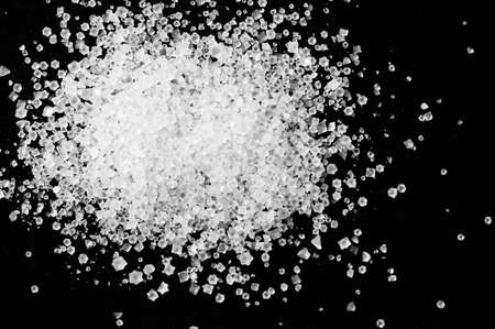Macro detail of salt crystal grain on black background.の写真素材