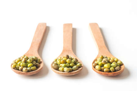 Green mung beans in wood spoon on white background.の写真素材