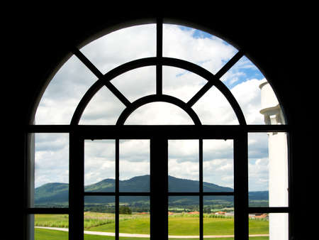 View of green hill through window.の写真素材