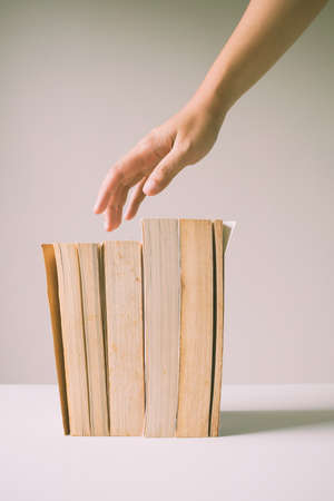 Hand over standing old books. Vintage image processed.の写真素材