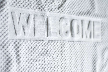 White welcome carpet mat shallow depth focus.の写真素材