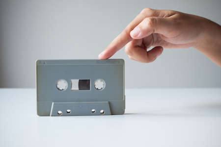 Hand point finger on old retro cassette tape. Vintage image processed.の写真素材