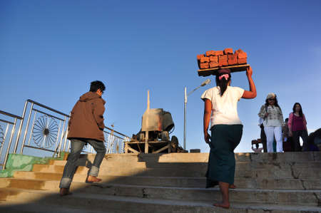 Kyaikto, Myanmar -  October 22, 2015 .Local woman worker put the bricks on head while walking to...