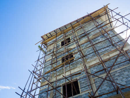 Under construction building with wood scaffolding.の写真素材
