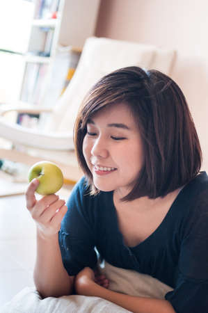 Young asian woman holding green apple with happy smiling.