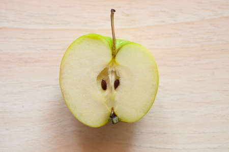 Half of green apple on wood background