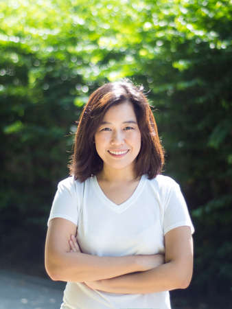 Asian woman smiling happy on sunny summer or spring day outside in parkの写真素材