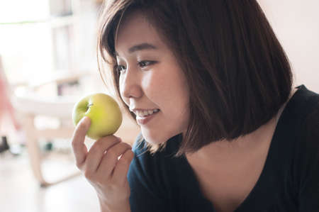Young asian woman holding green apple with happy smiling.の写真素材