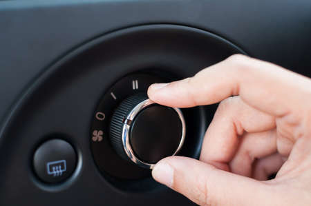 Hand turning dial button of air condition fan control panel.の写真素材