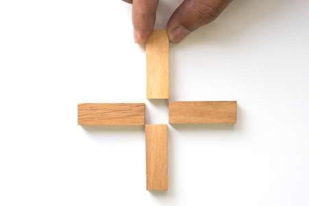 Hand aranging wood block as plus sign. Business concept for positive thinking.の写真素材