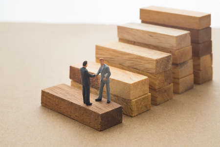 Businessmen checking hand on first step of wood stair, Successive business concept.
