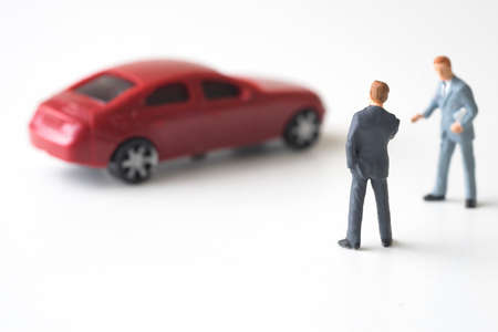 Businessman with car dealer thinking to buy a new red sport car.の写真素材