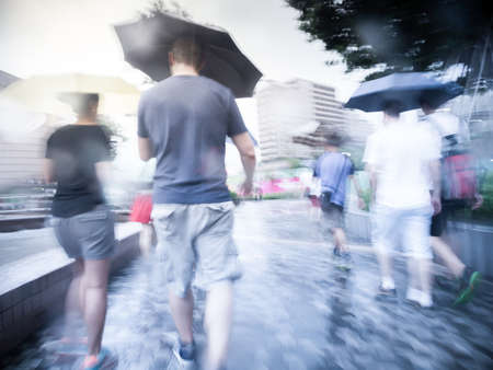 People walking in the street on a rainy day motion blurred.の写真素材