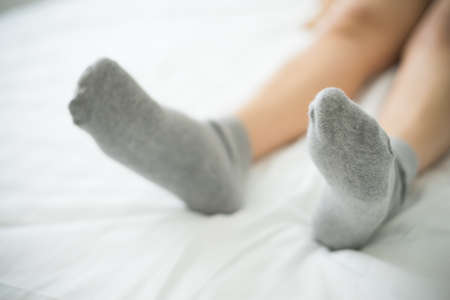 Woman wearing socks on bed shallow depth focus.