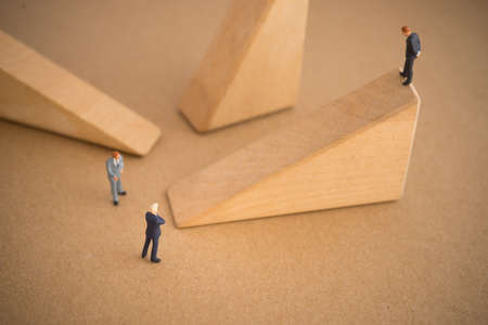 Businessman thinking or making decision in front slope ladder wood blockの写真素材