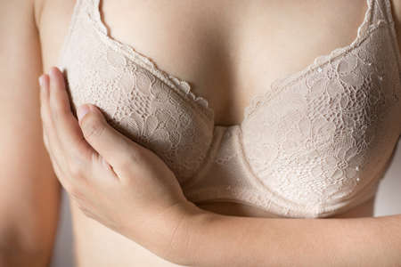 Woman touching breast with beige bra.の写真素材