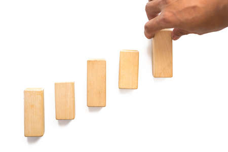 Hand aranging wood block stacking as step stair. Business concept for growth success process.の写真素材
