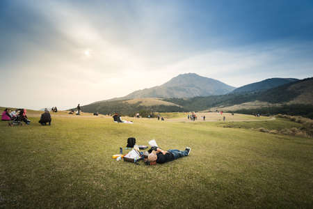 Taipei, Taiwan - March 05, 2016 : People relaxing on green grass field at Qintiangang, Yangmingshan National Park. Qingtiangang is popular with picnicking students and families.のeditorial素材