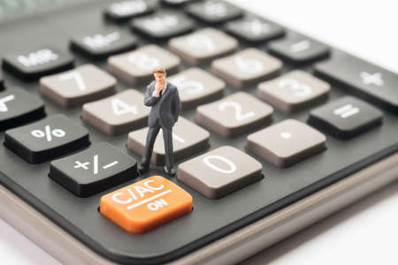 Business startup calculating concept. Businessman thinking or making decision with calculator.の写真素材