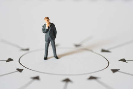 Business concept of Center management. Businessman standing and thinking at center of arrow pointの写真素材
