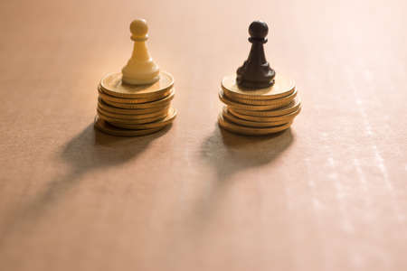 Concept of financial business competition. Chess pawn on coins stack.の写真素材