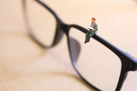 Businessman reading a book sitting on eyeglasses.の写真素材