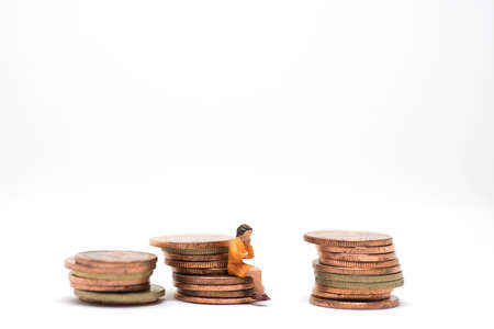 Concept of business budget management. Thinking woman sitting on coin stack.