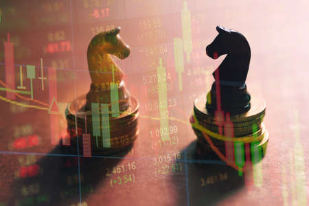 Concept of stock market strategy. Stock market number on screen display with Coin stack and chess knightの写真素材